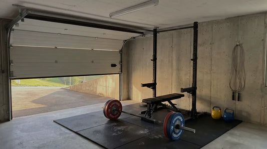 Garage Gym mit Squat Rack, Langhantel mit farbigen cross equip Bumper Plates und Gummiboden – Garagentor halb offen