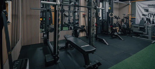 cross equip Flachbank im Power Rack eines Schweizer Home Gyms mit Gummiboden und Langhantel in den Ablagehaken