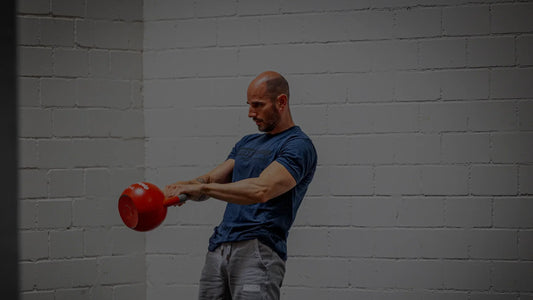 Kettlebell Swing im oberen Umkehrpunkt: die Kugel steht auf Brusthöhe, die Arme sind locker gestreckt.