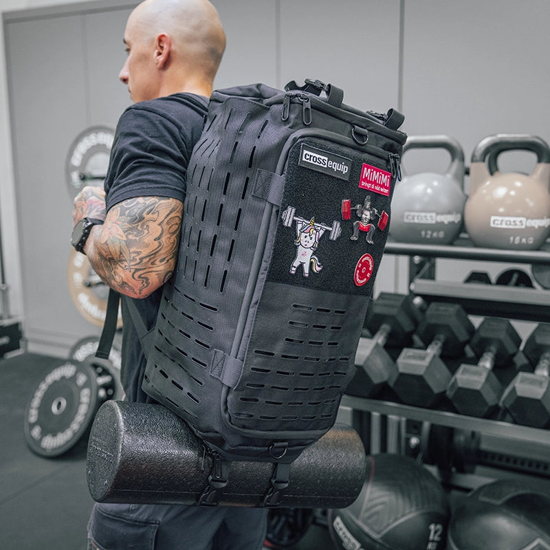 Mann trägt Cross Equip Hybrid Bag mit Patches auf dem Rücken im Gym