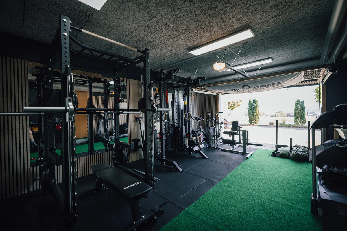 Home Gym in Reichenburg SZ mit offenem Garagentor, Rack und Kunstrasen, ausgestattet von cross equip