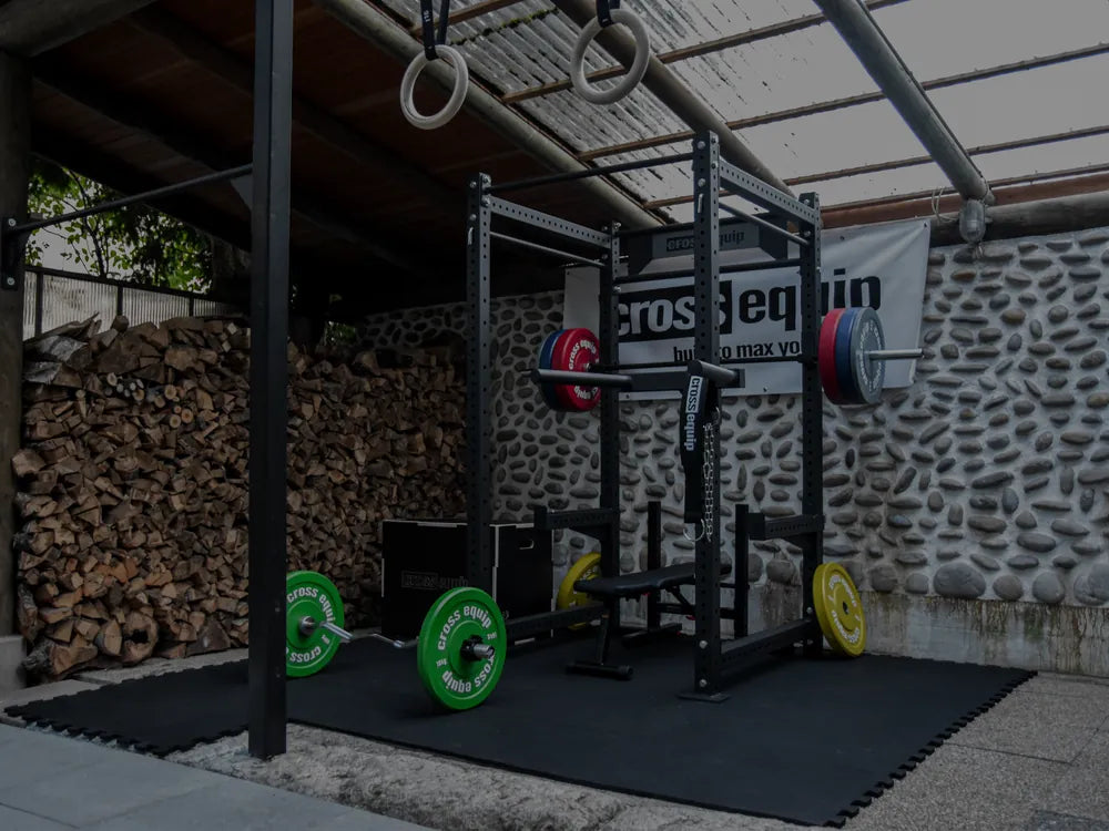 Outdoor-Homegym mit Power Rack und Bumper-Plates von cross equip unter ueberdachtem Aussenbereich