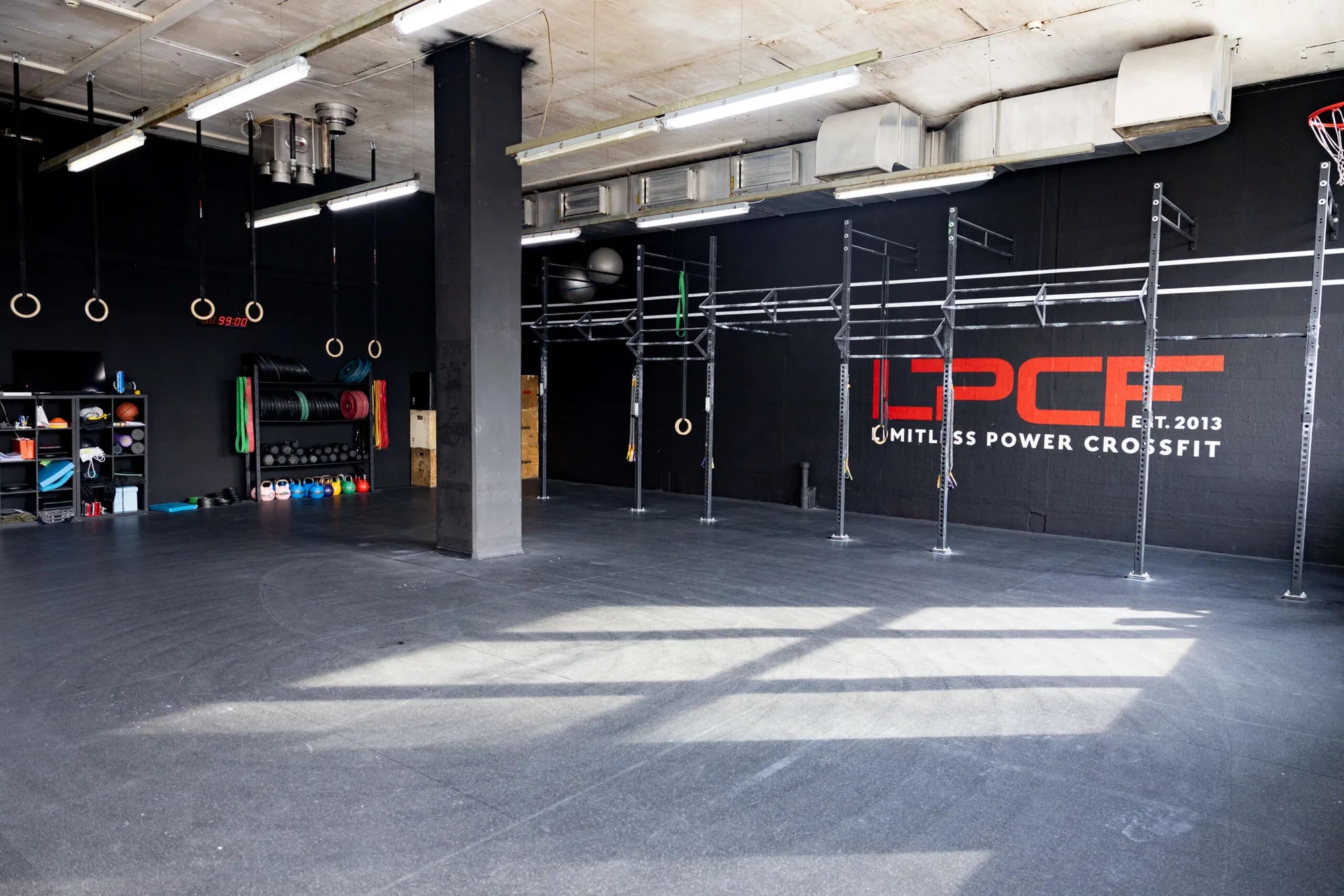 Limitless Power CrossFit in Kriens: Klassenraum mit Rig, LPCF-Logo und Materialwand, eingerichtet von cross equip