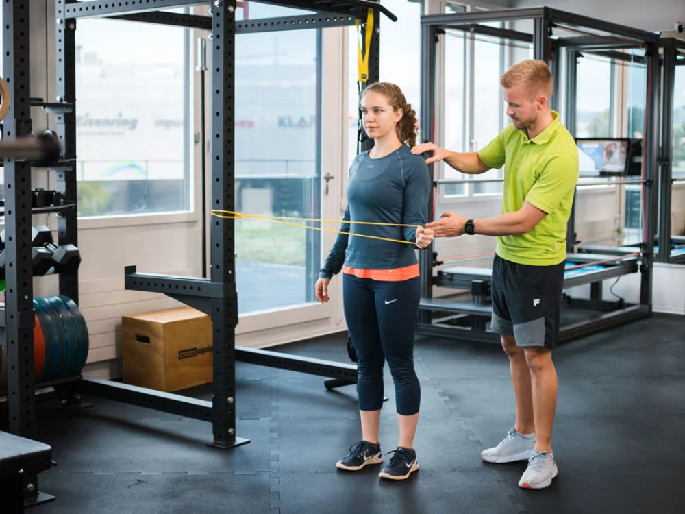 Rehabilitation mit Theraband auf der Trainingsfläche der PhysioBase Volketswil